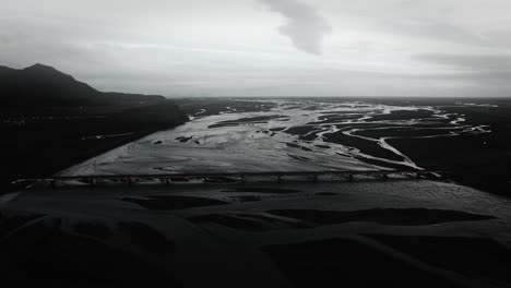 aerial flying: bridge leading over glacial river bed in iceland landscape view