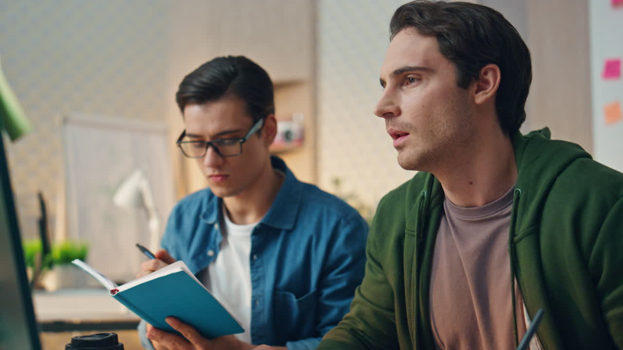 dos hombres discutiendo con la computadora en el lugar de trabajo en primer plano. trabajo en equipo cooperación