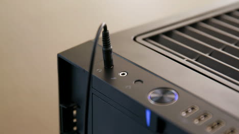 Man-Plugs-then-Unplugs-Headphone-Cable-into-Jack-on-Desktop-Computer