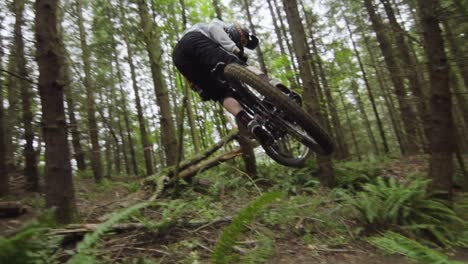 experienced downhill mountainbiker performing classic whip on dirt feature, slow