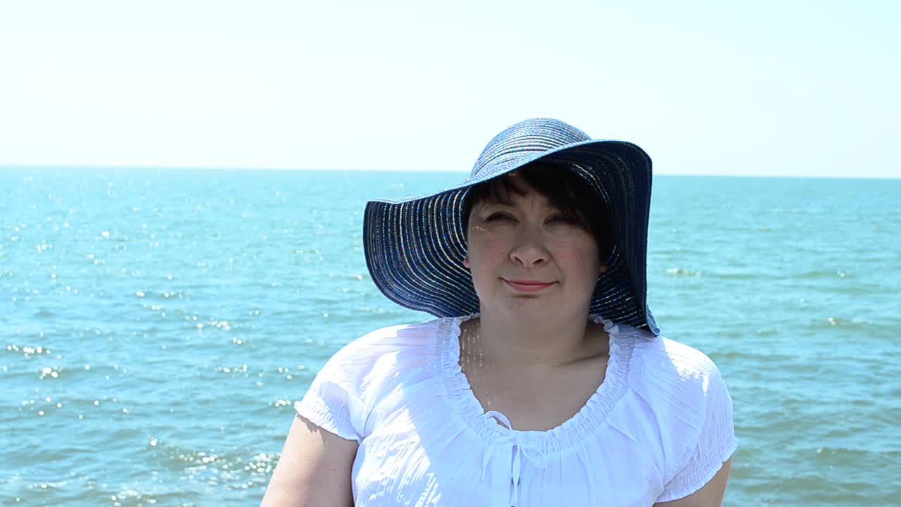 海を背景に帽子をかぶった少女。少女と海。