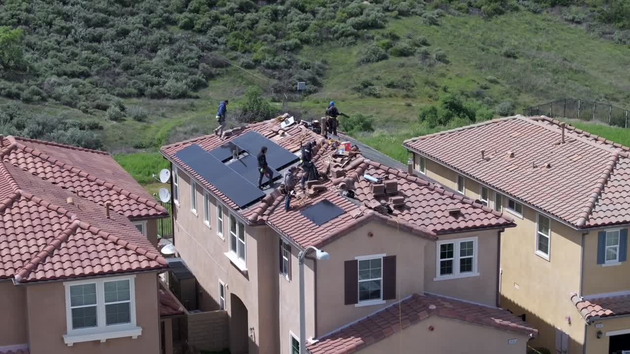 Workers Installing Solar Panels On A House Rooftop In Los Angeles, California. Aerial Shot.