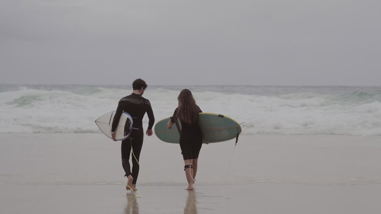Two Surfers Walking into the Ocean
