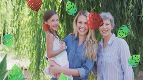 animación de corazones y hojas sobre sonrientes mujeres multigeneracionales caucásicas en el jardín