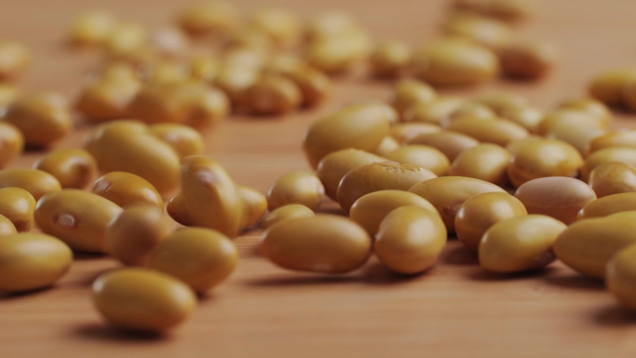 Slow Motion Close-Up of Yellow Beans Falling on Wooden Surface
