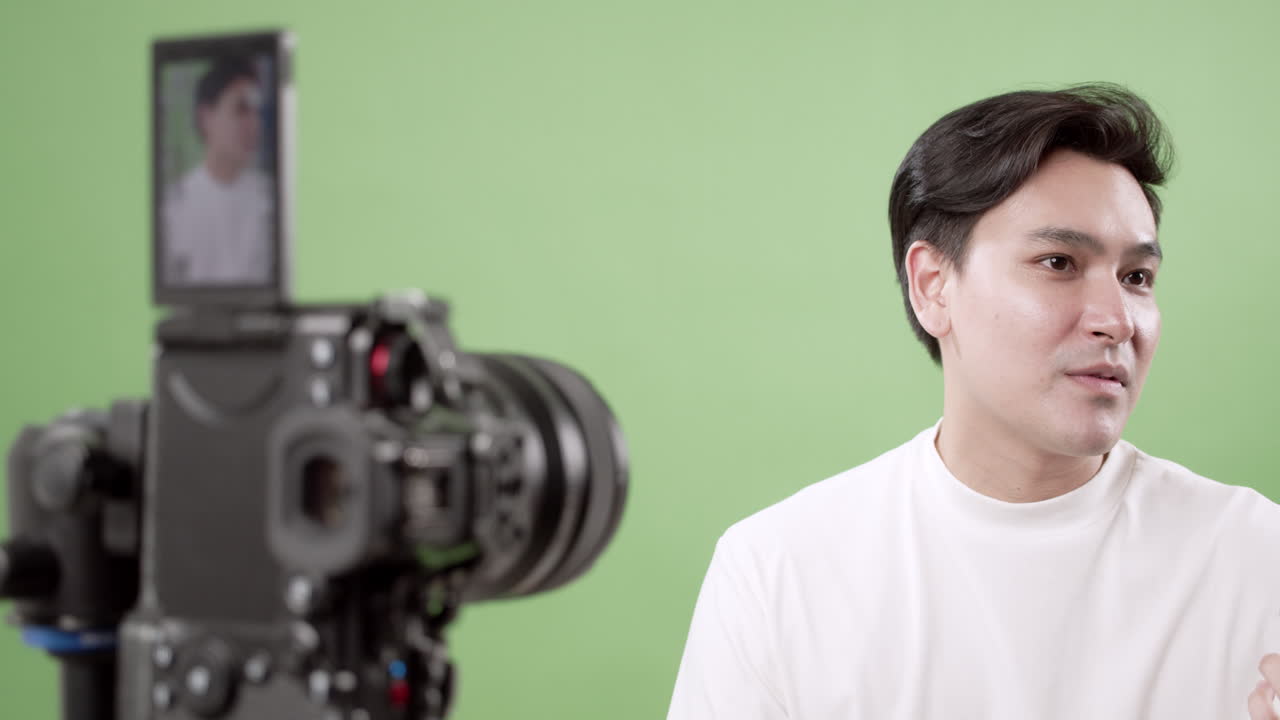 Young man in a white shirt passionately discusses the importance of social media content creation and communication skills. Set against a vibrant green background, this video inspires creativity.