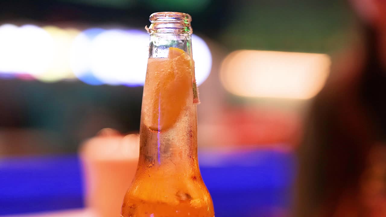 una botella de cerveza en medio de la vibrante vida nocturna de bangkok