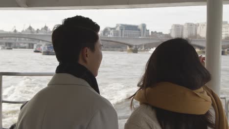 Young-Asian-Couple-On-Holiday-Taking-Trip-On-Thames-River-Boat-In-London-UK-1