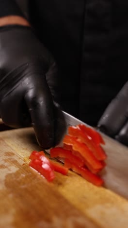 el chef cortando pimientos rojos