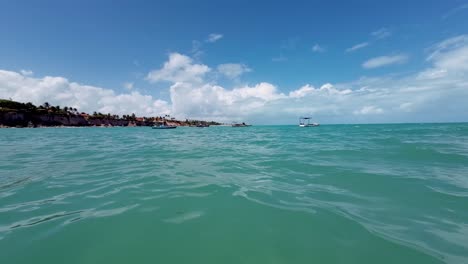 Handheld-action-camera-shot-from-inside-the-ocean-with-tropical-turquoise-water-at-the-Tambaba-beach-in-Conde,-Paraiba,-Brazil-on-a-warm-sunny-summer-day