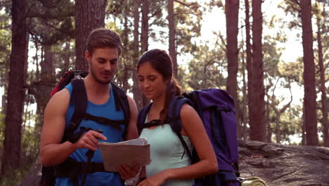 pareja descansando después de hacer senderismo y mirando el mapa