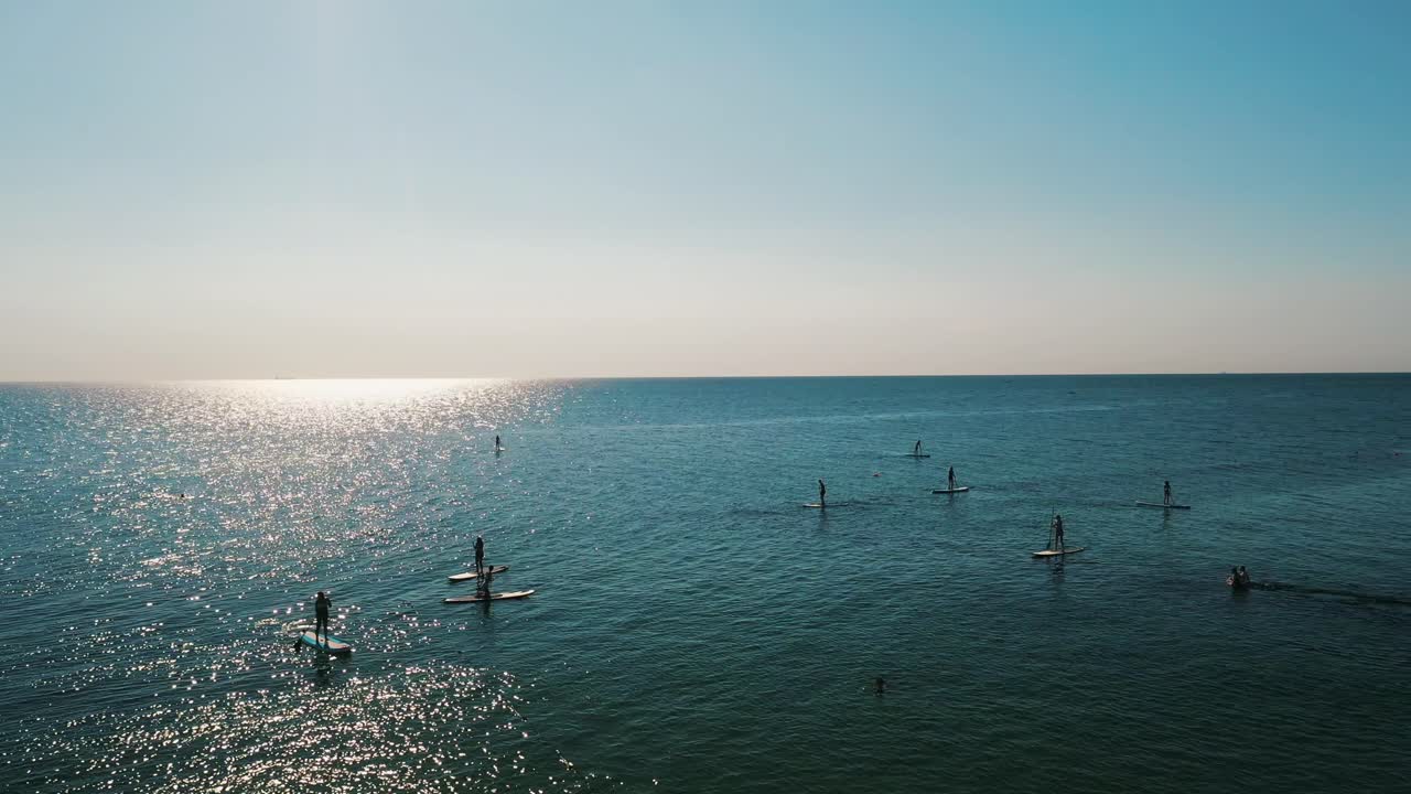 la gente se pone de pie para hacer paddle boarding en un día soleado