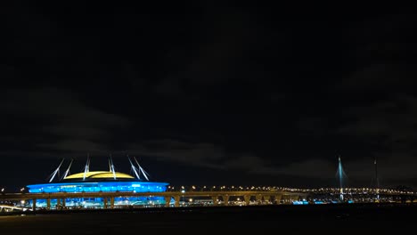 vista nocturna de un estadio y un puente
