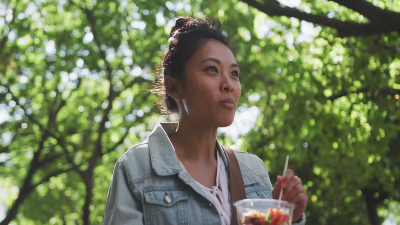 Mixed race woman eating while walking