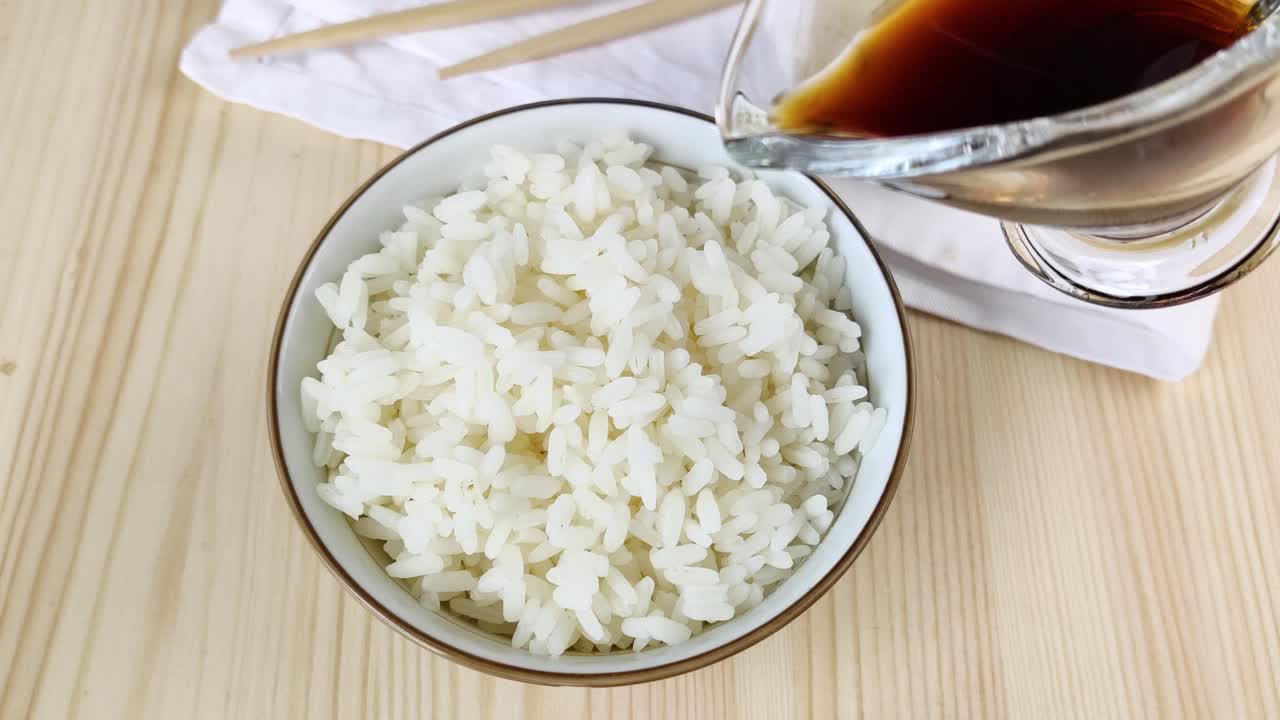 Boiled white long-grain rice is watered with soy sauce