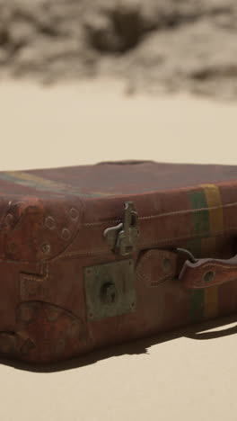 vintage leather suitcase on sand