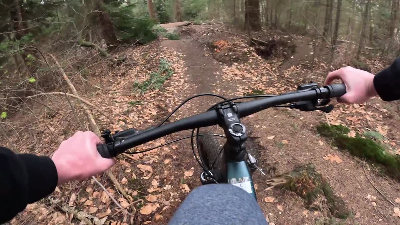 Video av mountainbikecykling genom träden på en stig.