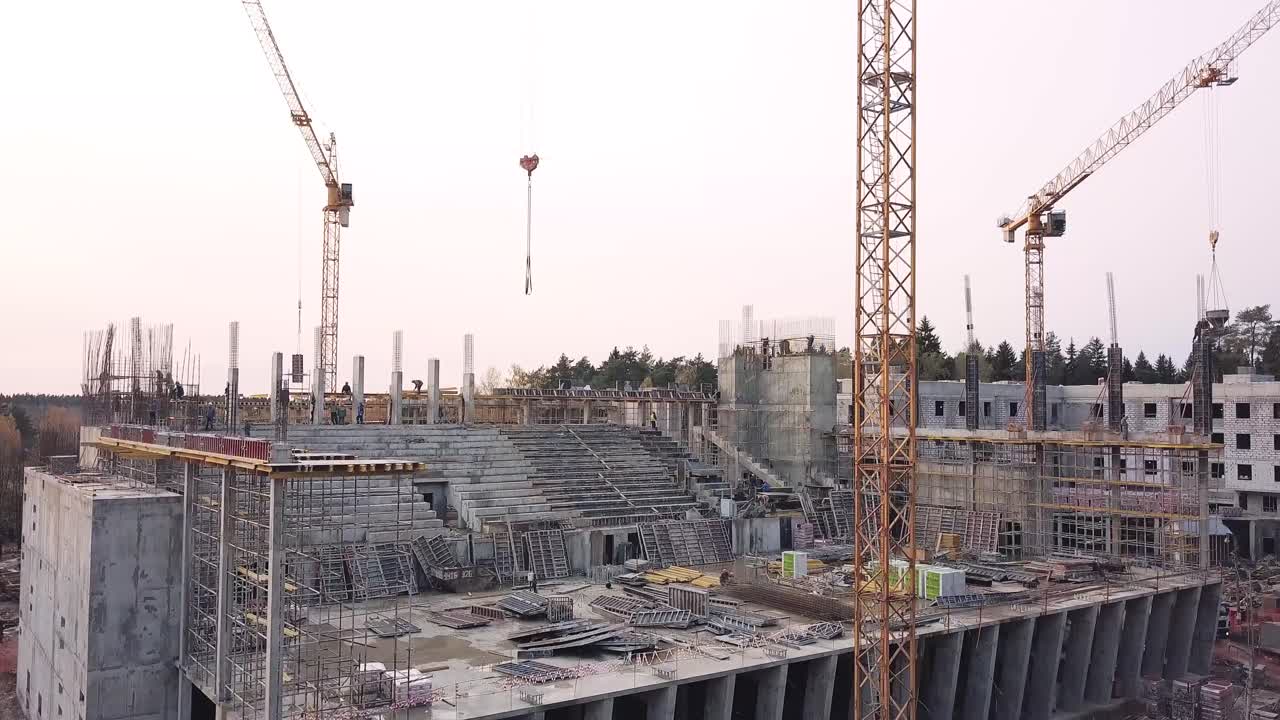 sitio de construcción con grúas y estadio