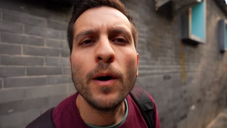 man blows air onto the camera lens to clean it on a street in beijing