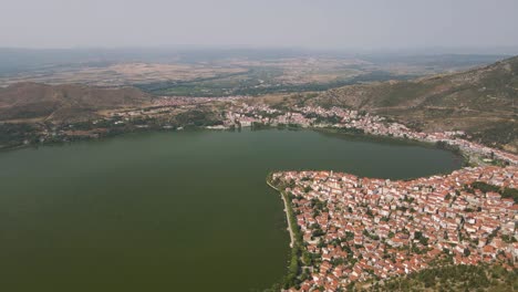 Clip-Aéreo-Sobre-Una-Montaña-Que-Revela-La-Ciudad-Y-El-Lago-De-Kastoria,-En-El-Norte-De-Grecia