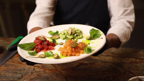 chef presenting a plate of colorful seafood dishes