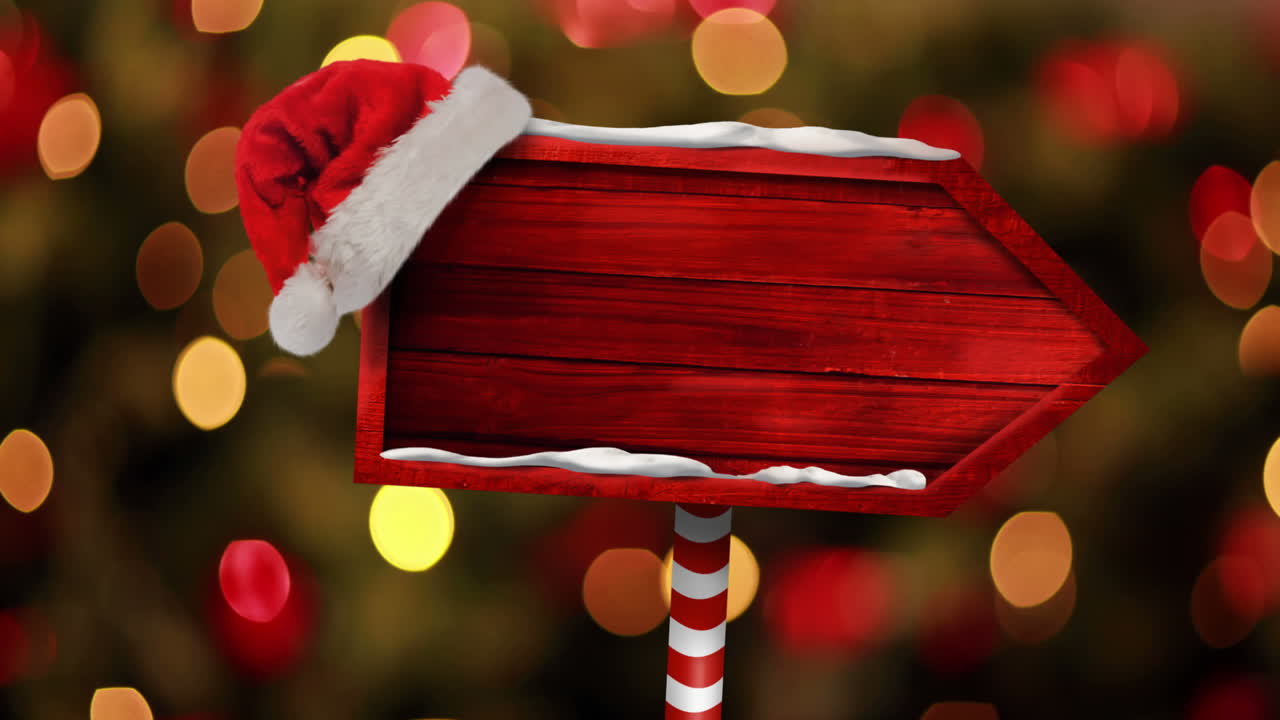 animación de la flecha de navidad con sombrero de santa sobre luces borrosas