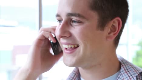 Casual-businessman-smiling-and-talking-on-phone