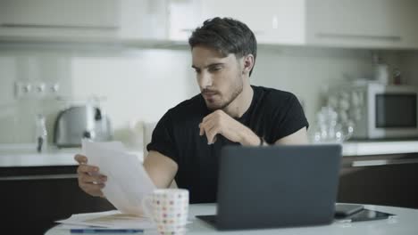 Businessman-looking-paper-at-home-workplace.-Young-business-man-work-with-papers