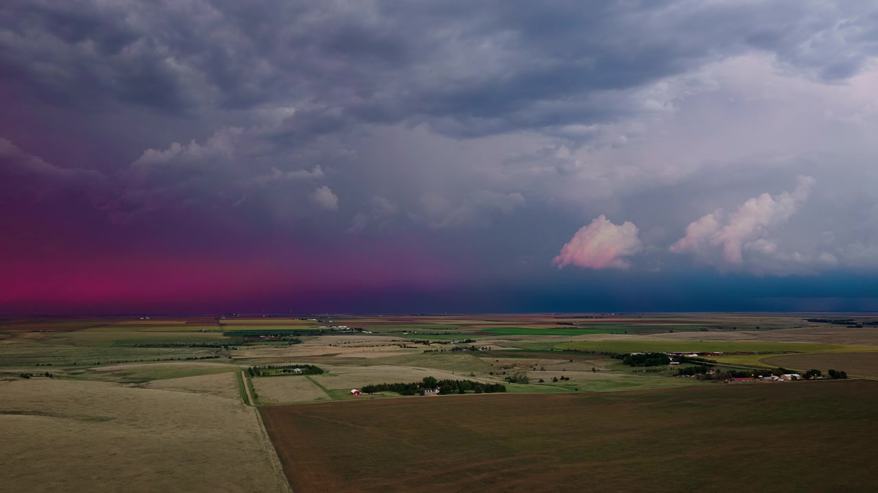 Jordbrukslandskap och blixtstorm, dramatisk himmel fylld med varma solnedgångsfärger, 4K-flygfilm.