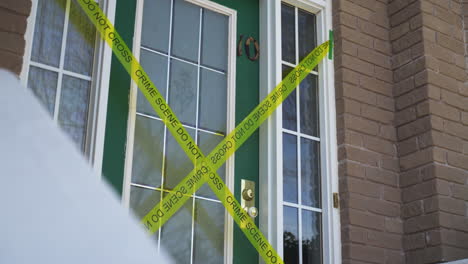escena del crimen amarilla no cruce la cinta a través de la puerta principal de la casa