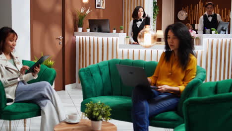 Asian-women-passing-time-in-lounge-area-at-hotel