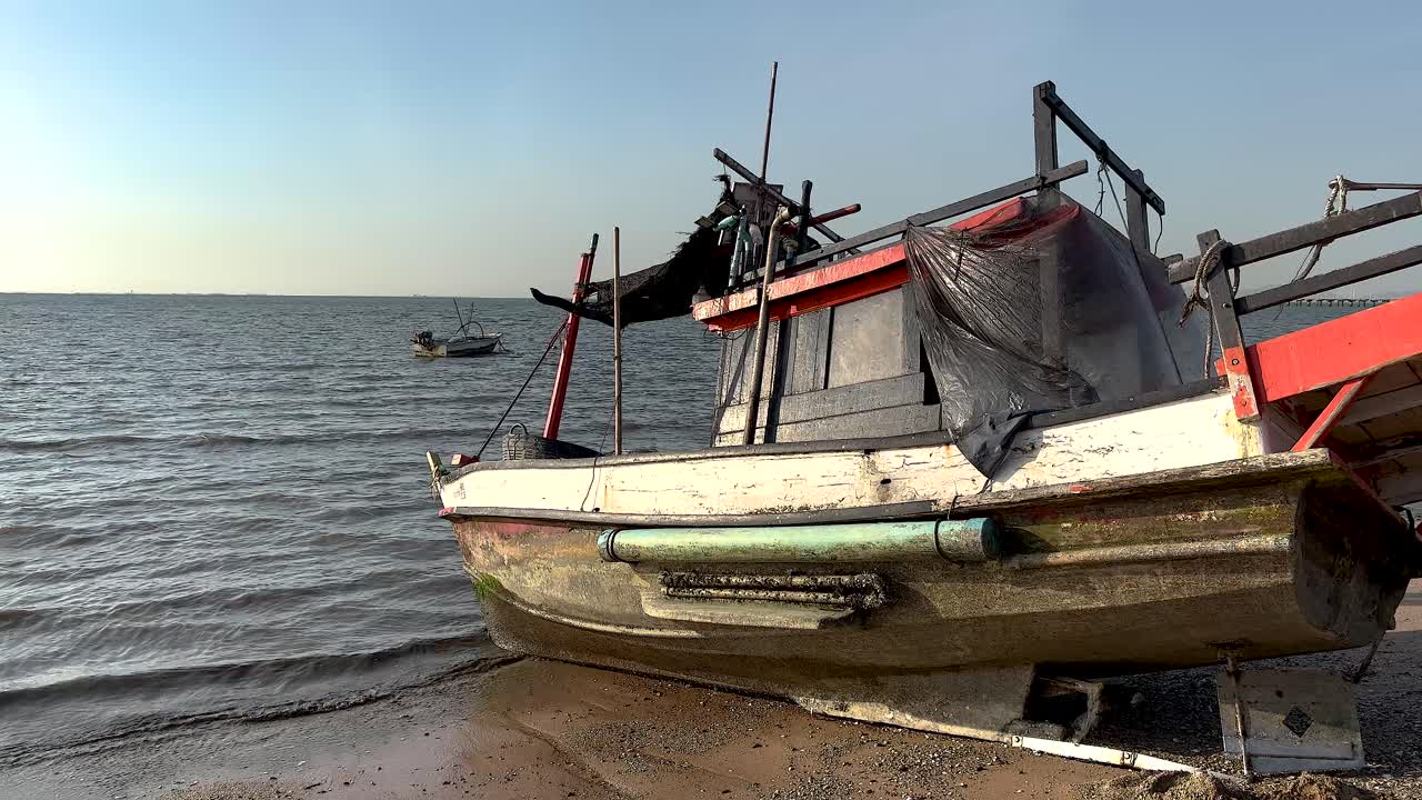 Una barca rotta giace su una riva sabbiosa