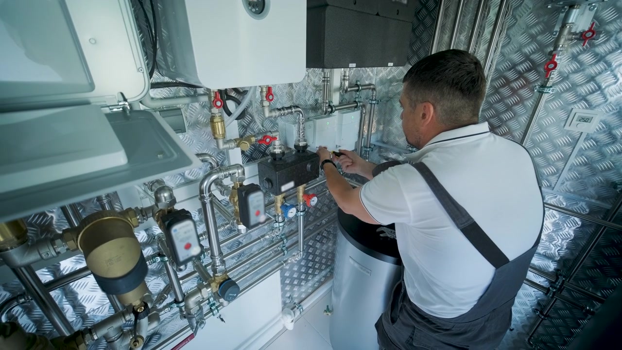 Technician Installing Heating System Components in Utility Room