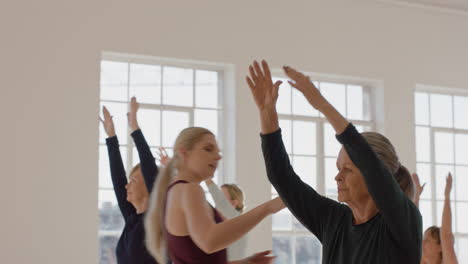 yoga class of healthy mature women practicing warrior pose enjoying physical fitness workout instructor teaching group in exercise studio