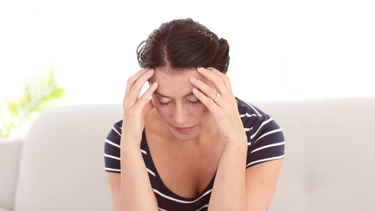 mujer triste sentada en el sofá