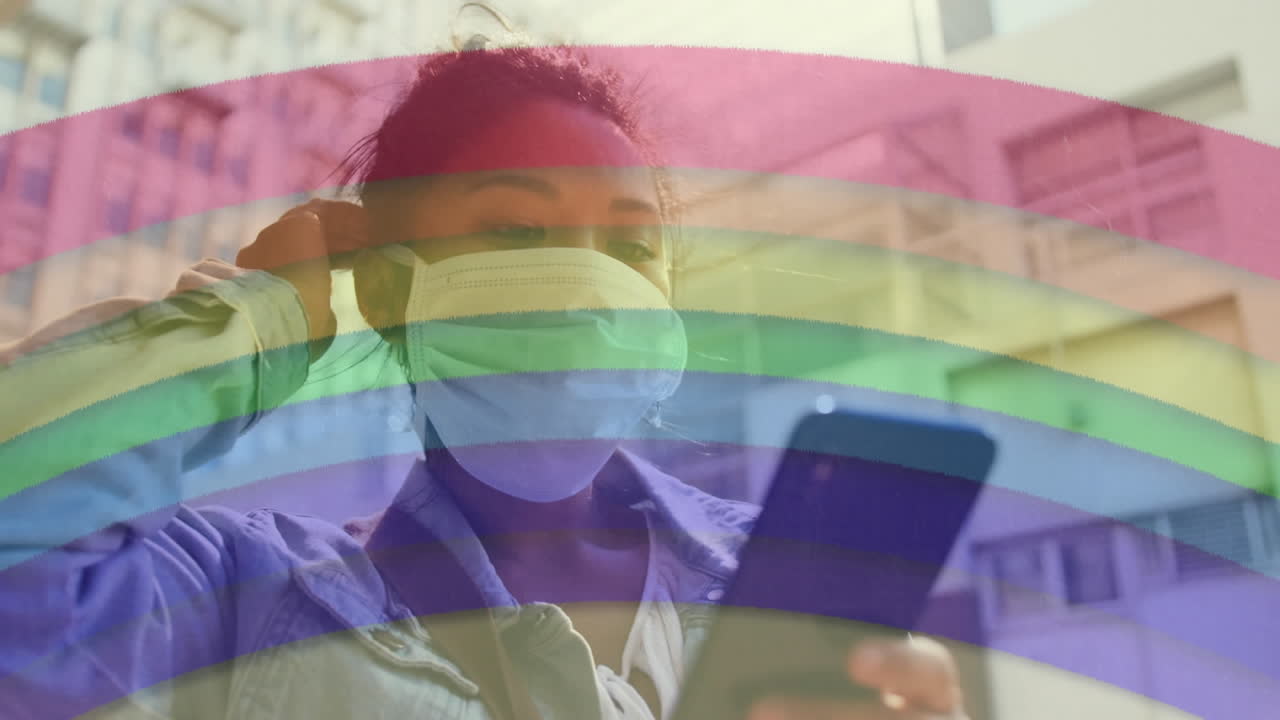 스마트 폰을 사용하여 얼굴 마스크를 착용 한 여성에 대한 무지개