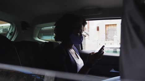 African-american-woman-wearing-face-mask-in-car