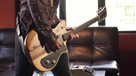 un hombre toca la guitarra en su estudio