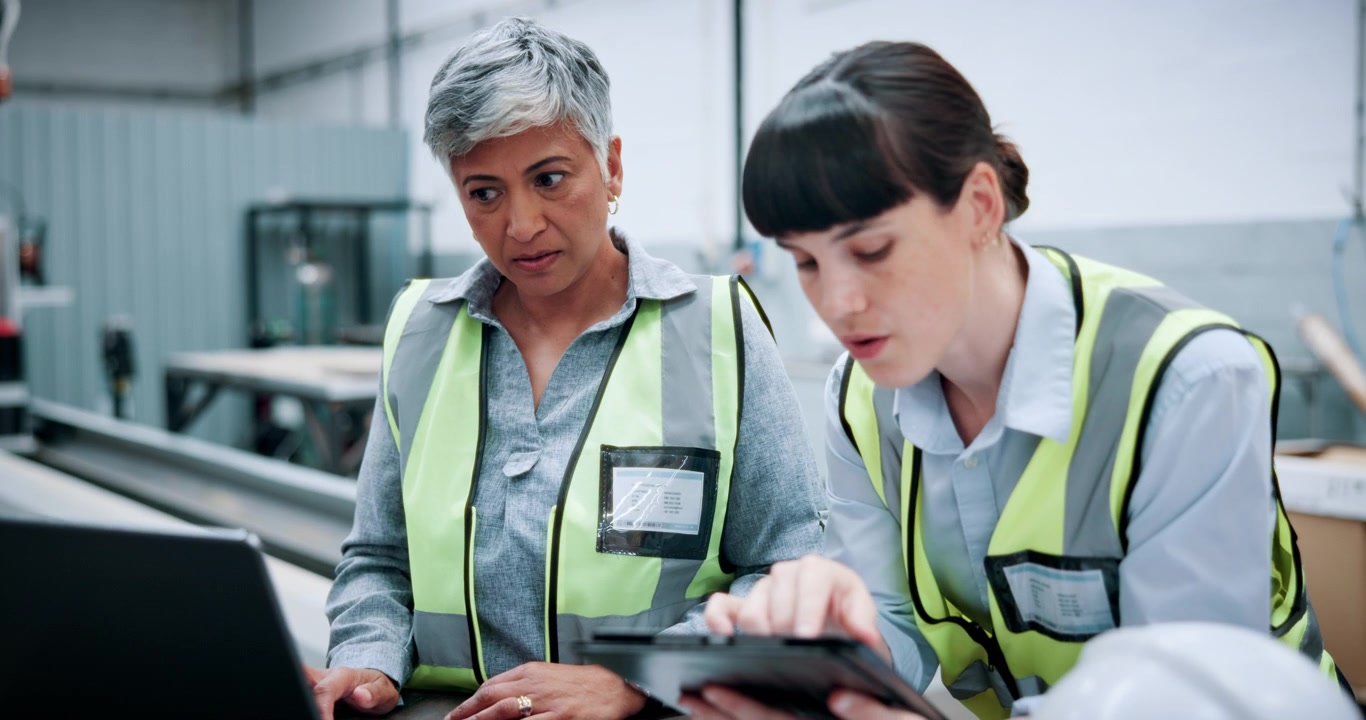 Female Engineers Collaborating on Laptop in Industrial Factory