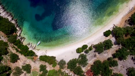 Drohnenaufnahme-Des-Atemberaubenden-Kristallklaren-Wassers-Und-Der-Weißen-Kieselsteine-Des-Foki-Strandes,-Nur-Wenige-Kilometer-Vom-Weltberühmten-Dorf-Fiskardo-In-Griechenland-Entfernt