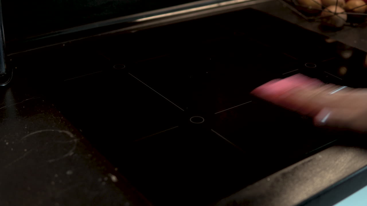 Cleaning black induction hob by colored rag, cleaning household electrical appliances