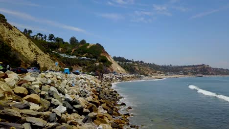 north malibu, california, surfers near the rocks