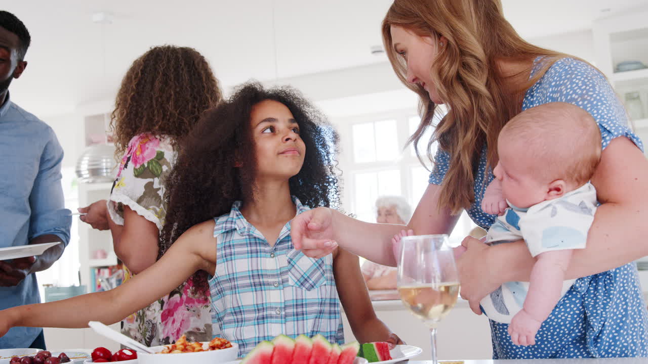 축하 파티 를 위해 주방 에 모이는 다세대 가족 과 친구 들 의 느린 동작 촬영