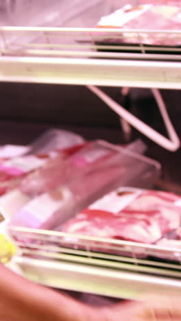 trabajador de alto nivel almacenando el refrigerador en el supermercado