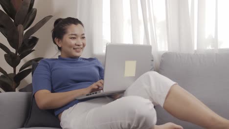 asian businesswoman authentic shot using a laptop to work from home happily