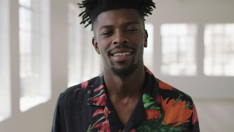 Retrato-En-Cámara-Lenta-De-Un-Hombre-Afroamericano-Relajado-Sonriendo-Mirando-La-Cámara-Disfrutando-De-Un-Cambio-De-Estilo-De-Vida-Usando-Camisa-Hawaiana-En-Un-Apartamento-Nuevo