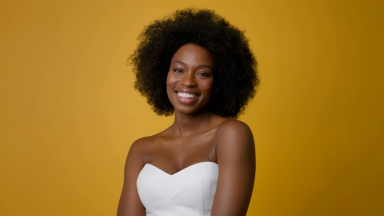 Smiling Black Woman with Afro Hair on Yellow Background