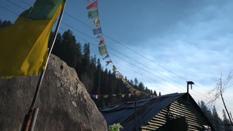 clip en cámara lenta de la tienda de té himachal en sethan manali banderas coloridas y línea de árboles detrás del viaje estético cinematográfico