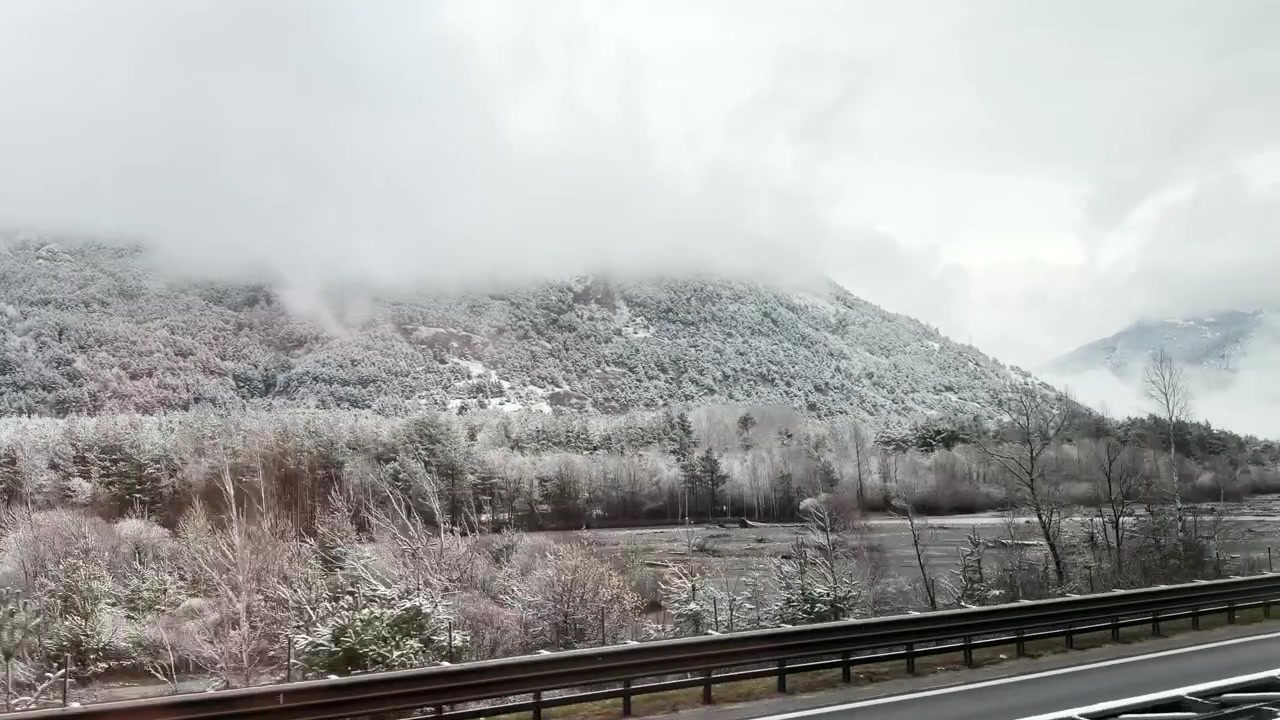 走行中のバスから見た、イタリアのトリノ近郊の雪山と沿道の風景