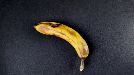 banana rotating steadily on seamless black background for product, ad, or packaging visuals, top down